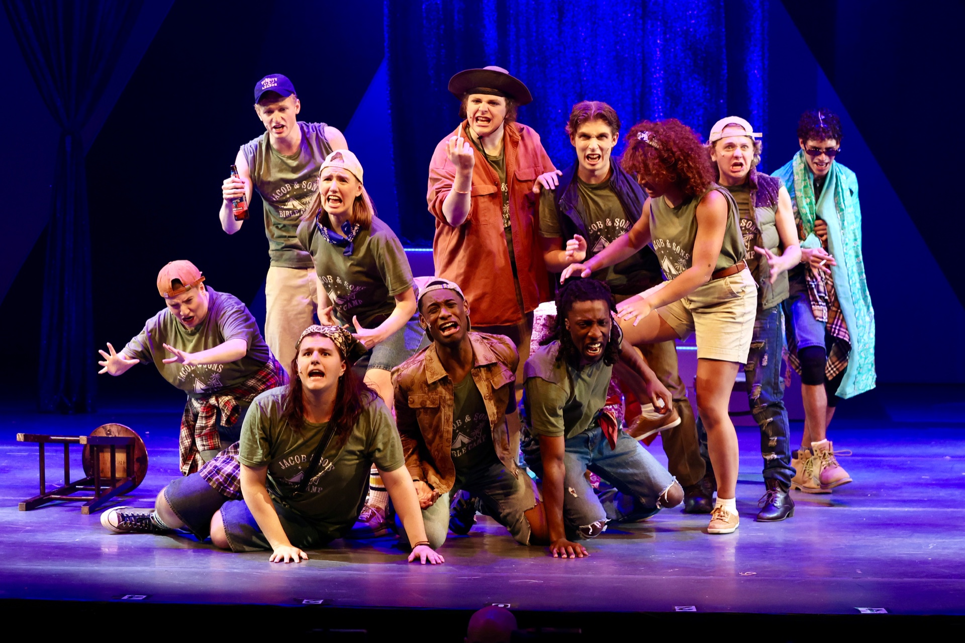 A dozen performers in matching green Jacob & Sons Bible Camp shirts crowd the stage and wail toward the audience, several kneeling in front.